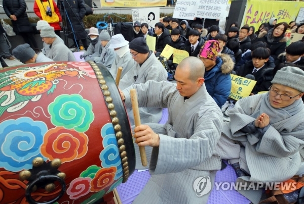 6일 오후 서울 종로구 옛 주한일본대사관 앞에서 정대협 주최 '일본군 위안부 문제 해결을 위한 정기 수요시위'에 조계종 사회노동위원회 회원이 참석하여 북을 두드리고 있다. (출처: 연합뉴스)