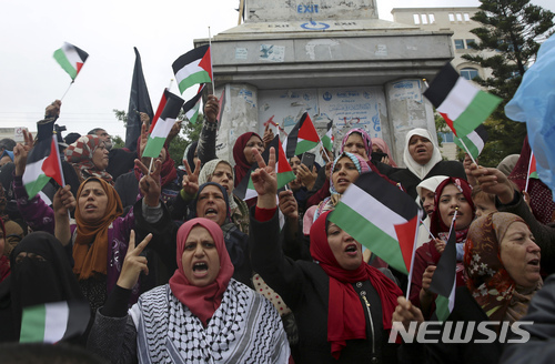 6일 가자 지구 내 무명의 용사 광장에서 여성들이 팔레스타인의 국기를 흔들며 예루살렘을 이스라엘 수도로 인정한 트럼프 미 대통령을 규탄하고 있다. (출처: 뉴시스)