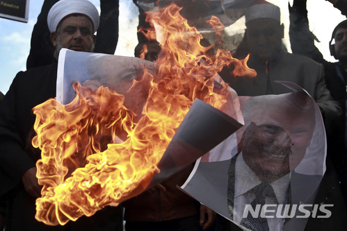 7일(현지시간) 가자지구에서 팔레스타인인들이 도널드 트럼프 미국 대통령과 베냐민 네타냐후 이스라엘 총리의 사진을 불태우고 있다. (출처: 뉴시스)
