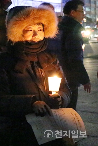 [천지일보=이지솔 기자] 한국기독교교회협의회(NCCK)와 세계교회협의회(WCC)가 8일 오후 서울 광화문 북측 광장에서 ‘전쟁을 내려놓고 평화를 일구어라’를 주제로 대림절 촛불 기도회를 열고 있는 가운데 한 교인이 촛불을 켜 들고 있다. ⓒ천지일보(뉴스천지) 2017.12.8