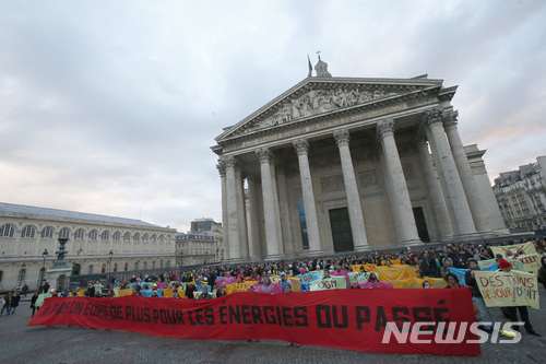 【파리=AP/뉴시스】환경운동가들이 12일 프랑스 파리 팡테옹 광장에서 파리 기후협정 이행을 촉구하는 시위를 벌이고 있다.이들이 들고 있는 대형 플래카드에는 '과거의 에너지에는 단 1유로로 안된다'고 쓰여있다. 이날 파리에서는 50여개국 정상들이 모여 기후협정 이행방향을 논의하는 국제회의가 개최됐다. 파리협정 탈퇴를 선언한 도널드 트럼프 미국 대통령은 불참했다. 2017.12.12