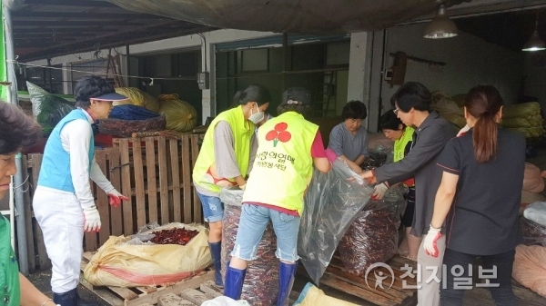 사랑의 열매 자원봉사단이 지난 7월 폭우 피해를 본 전통시장에서 복구 작업을 하고 있다. (제공: 천안시) ⓒ천지일보(뉴스천지) 2017.12.20
