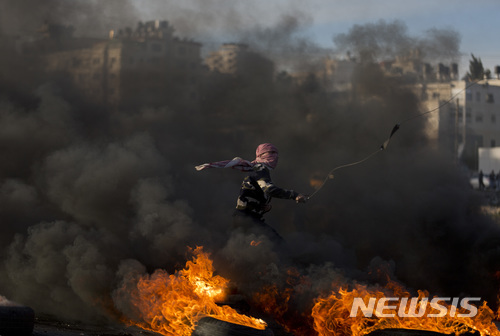 도널드 트럼프 대통령의 예루살렘 이스라엘 수도 인정 발언 후 팔레스타인 서안지구 라말라 시내에서 11일 (현지시간) 팔레스타인 시위대가 타이어를 불태우면서 시위를 벌이고 있다. (출처: 뉴시스)