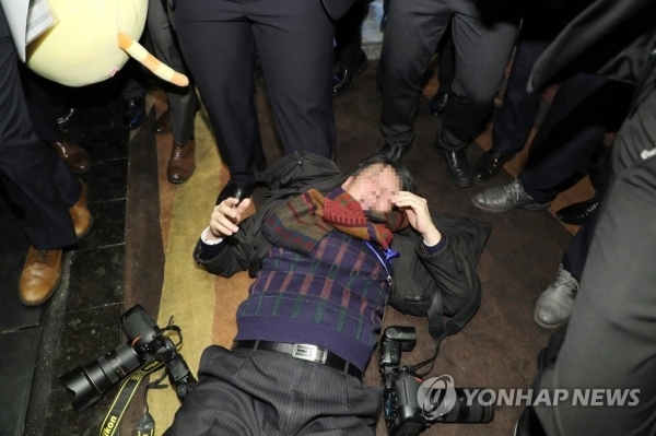 지난 14일 오전 문재인 대통령 국빈방문 행사를 취재하던 한국의 한 사진기자가 베이징 국가회의중심 B홀에서 중국 측 경호 관계자에게 폭행을 당해 쓰러져 있다. (출처: 연합뉴스)