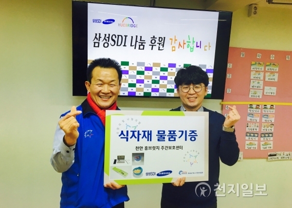 삼성SDI 천안사업장이 지난 28일 김학일 천안시휴브릿지주간보호센터장(오른쪽)에게 장애인식사보조기기를 전달하고 있다. (제공: 천안시휴브릿지주간보호센터) ⓒ천지일보(뉴스천지) 2017.12.29