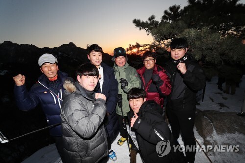 문재인 대통령(뒷줄 가운데)이 1일 오전 ‘2017년 올해의 의인’으로 선정된 시민들과 함께 북한산 사모바위를 등반해 떠오르는 태양을 맞이하며 기념 촬영을 하고 있다. (출처: 연합뉴스)