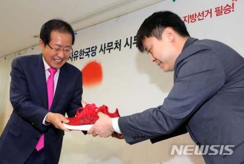 2일 오전 서울 여의도 자유한국당 당사에서 열린 사무처 시무식에 참석한 홍준표 대표가 지방선거 필승을 기원하는 빨간색 운동화 선물을 받고 있다. (출처: 뉴시스)