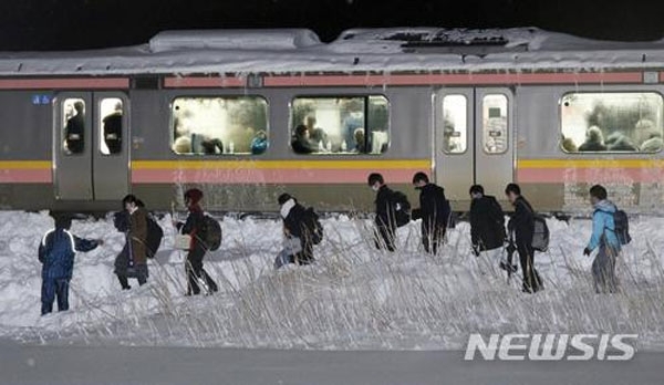 【산조(니가타현)=AP·교도/뉴시스】 일본 니가타(新潟)현 산조(三条)시에서 지난 11일 오후 7시께 폭설의 영향으로 JR신에쓰선 열차가 멈춰서면서 승객 430여명이 열차 안에 갇힌 채 밤을 지새웠다. 사진은 12일 오전 열차의 모습으로 열차 안에 승객들의 모습이 보인다. 해당 열차는 12일 오전 10시 반께 운행을 재개했다.