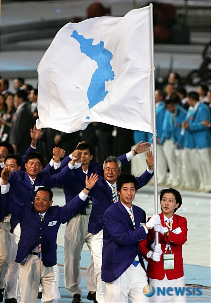 지난 2005년 남북한 공동기수인 남한 양희종(22, 남자농구,193㎝)과 북한 류현순(23, 여자농구,177㎝)이 굳게 잡은 한반도기를 앞세우고 제4회 마카오 동아시아경기대회에 참가한 남북한 선수들이 입장하고 있다. (출처: 뉴시스)