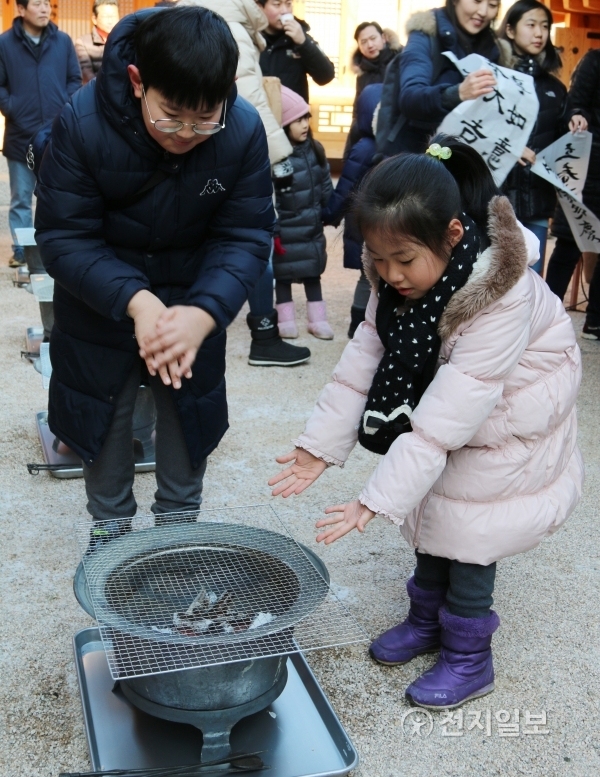3일 열린 상촌재 입춘행사에서 아이들이 매서운 바람으로 인해 차가워진 손을 화롯불에 녹이고 있다. ⓒ천지일보(뉴스천지) 2018.2.3