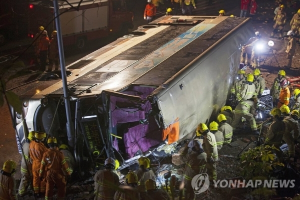 10일(현지시간) 홍콩 타이포루(路)의 이층버스 전복 현장에서 응급 구조대원들이 사고처리 작업을 하고 있다. 이날 승객을 가득 태운 이층버스가 전도돼 19명이 숨지는 참사가 발생하기 전 버스 기사와 승객들이 심하게 다퉜다는 증언이 나왔다. (출처: 연합뉴스)