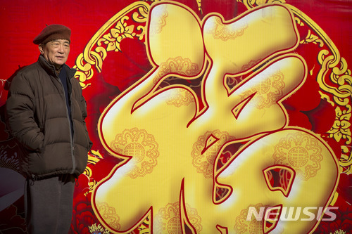 【베이징=AP/뉴시스】 중국 증시가 15~21일 춘제 연휴로 장기 휴장에 들어갈 예정인 가운데 투자자들이 관망세를 보일 것으로 예상된다. 지난 10일 베이징의 한 공원에서 한 남성이 대형 복(福) 옆에 서있다.