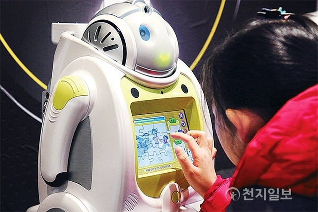 여자 어린이는 학습용 로봇의 스크린을 직접 터치해보고 있다. ⓒ천지일보(뉴스천지) 2018.2.14