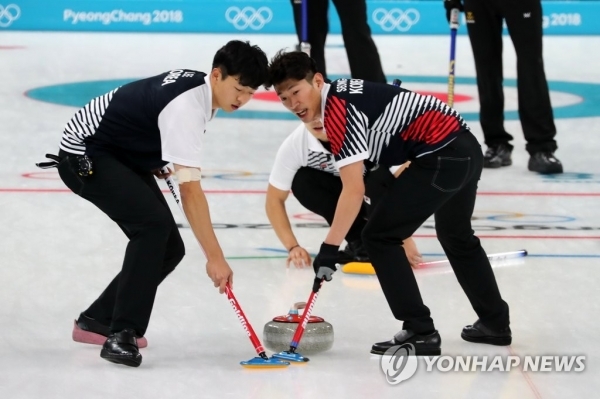(평창=연합뉴스) 14일 강릉컬링센터에서 열린 남자 컬링 대한민국과 스웨덴의 경기에서 한국의 이기복(왼쪽)과 성세현이 힘하게 스위핑하고 있다.