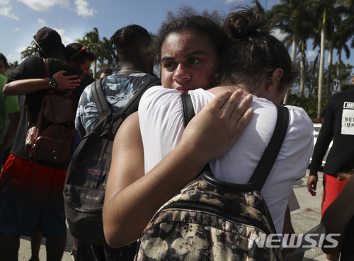 (Carline Jean/뉴시스) 23일(현지시간) 미국 플로리다주 디어 필드 고등학교 학생들이 11마일 떨어진 파크랜드 더글러스 고교에 방문해 17명의 목숨을 앗아간 총기 참사 사건을 당한 학생들을 위로하고 있다.
