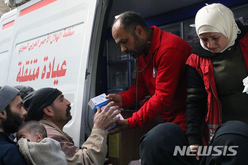 5일(현지시간) 시리아 동구타에서 주민들이 시리아적신월사가 지급하는 구호품을 전달받고 있다. (출처: 뉴시스)