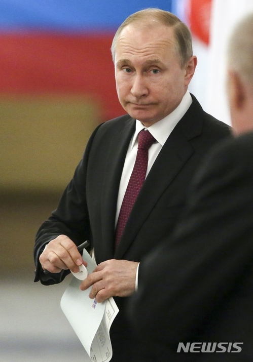18일(현지시간) 러시아 대선이 실시된 가운데 블라디미르 푸틴 러시아 현 대통령이자 대통령 후보가 모스크바 투표소에서 투표를 하고 있다. (출처: 뉴시스)