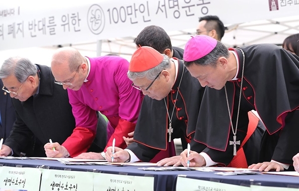 염수정 추기경(왼쪽 세 번째)이 3일 오후 서울 명동성당에서 열린 '낙태죄 폐지 반대를 위한 100만인 서명운동'에 참석해 서명하고 있다. 염 추기경 왼쪽은 마르코 스프리찌 주한교황청 대리대사, 오른쪽은 유경촌 티오테오 주교. (출처: 연합뉴스) 2017.12.3