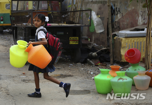 (AP Photo/뉴시스) 22일 인도 남부 방갈로르에서 한 중학생이 빈 플라스틱 물통을 등교하기 전 챙겨가고 있다. 방갈로르는 물 부족 문제가 심각한 지역 중 하나로 꼽히고 있다.