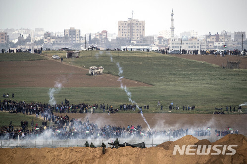 【가자=AP/뉴시스】 30일 가자 지구 경계선에서 이스라엘 군인들이 경계선 펜스까지 몰려온 팔레스타인 시위대에 최루탄 등을 발사하고 있다. 이날 충돌로 팔 인 5명 이상이 사망했다. 2018. 3. 30. (출처: 뉴시스)