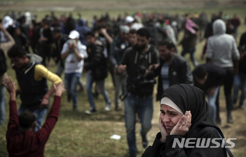 지난달 30일 가자 봉쇄펜스 부근에서 행진 시위에 참여한 한 팔레스타인 여성이 이스라엘 군인의 사격 소리에 귀를 막고 있다. (출처: 뉴시스)