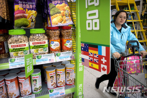 지난 3월23일 중국 베이징의 한 슈퍼마켓에서 여성 1명이 미국산 수입 견과류들이 진열된 전시대 옆을 카트를 밀고 지나가고 있다. 중국은 2일 약 30억 달러 상당의 미국산 돼지고기와 과일 등 농축산물에 높은 관세를 부과했다. (출처: 뉴시스)