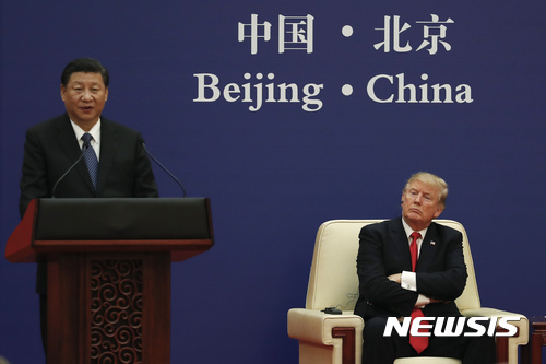 도널드 트럼프 미국 대통령이 지난해 11월 9일 베이징 인민대회당에서 열린 미중 기업인 행사에 참석해 팔짱을 낀 채 시진핑 중국 국가주석의 연설을 듣고 있다. (출처: 뉴시스)