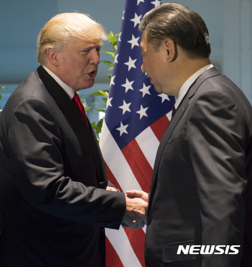 도널드 트럼프 미 대통령(왼쪽)이 지난해 7월 독일 함부르크에서 시진핑 중국 국가주석과 회담하기 전 악수하고 있다. (출처: 뉴시스)