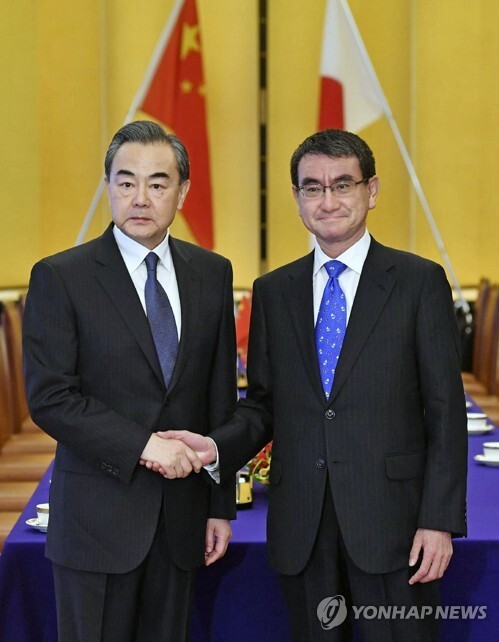 (도쿄 교도=연합뉴스) 15일 왕이 중국 외교담당 국무위원 겸 외교부장(왼쪽)과 고노 다로 일본 외무상이 도쿄 도내에서 회담에 앞서 악수하고 있다.
