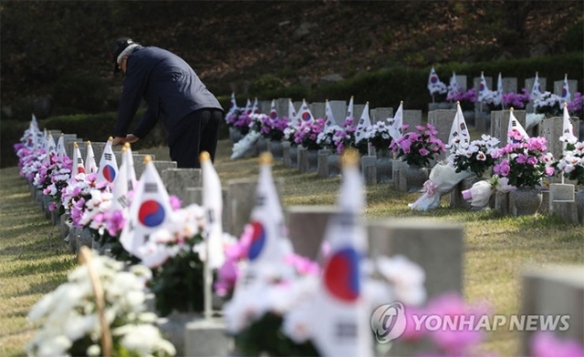 (서울=연합뉴스) 4.19 혁명 제58주년을 하루 앞둔 18일 서울 강북구 국립 4.19 민주묘지를 찾은 백발의 노인이 당시 동료의 묘비에 손을 올리고 있다.