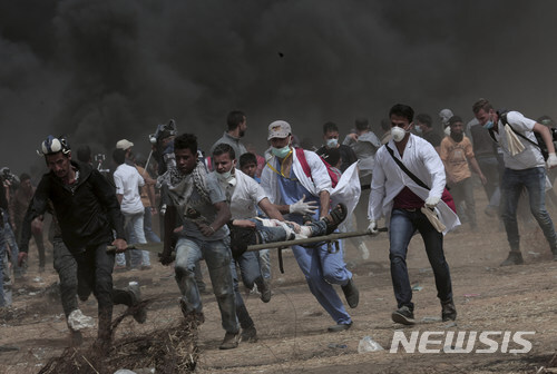【가자시티=AP/뉴시스】팔레스타인 가자지구에서 20일(현지시간) 이스라엘군과 팔레스타인 시위대 간 충돌로 4명이 숨지고 150여 명이 다쳤다. 이날 팔레스타인 구호대원들이 한 부상자를 옮기기 있다. 2018.04.21 (출처: 뉴시스)