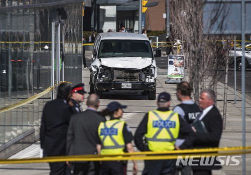 23일(현지시간) 캐나다 토론토에서 발생한 차량돌진사건로 최소 10여명이 사망하고 15명이 다쳤다. 사고 현장에서 경찰들이 사고차량 앞에 모여 있다. 이번 사건의 용의자는 25세 알렉 미나시안으로 경찰 당국은 그가 고의로 이같은 사고를 낸 것으로 보고 수사를 하고 있다. (출처: 뉴시스)