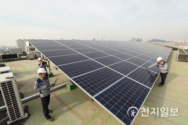 서울 관악구의 KT 구로타워 옥상에 구축된 태양광 발전소에서 KT의 에너지 전문인력들이 태양광 발전시설을 점검하고 있다. (제공: KT) ⓒ천지일보(뉴스천지) 2018.4.29