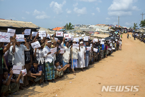 방글라데시로 도망온 미얀마의 로힝야 난민들이 29일 난민촌에서 유엔 안보리 조사단의 도착을 손팻말을 들고 끈질기게 기다리고 있다. 국경을 넘어온 70만의 로힝야들은 방글라데시 정착 대신 탄압과 차별의 미얀마로 다시 돌아가는 상황에서 자신들의 ‘신분’ 문제가 먼저 해결되기를 바라고 있다. 이들이 손에 들고 있는 종이에는 ‘국적확인카드(NVC)’ 반대 의사가 적혀 있다. (출처: 뉴시스)