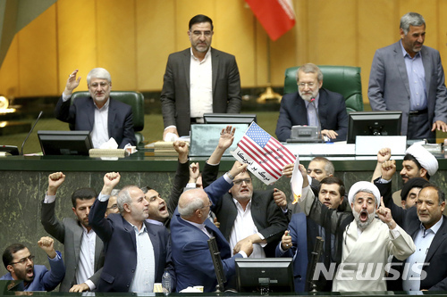 이란 국회의원들이 9일 테헤란의 국회의사당에서 미국의 이란 핵협정 탈퇴를 비난하며 종이로 만든 미 성조기를 불태우고 있다. 이들은 