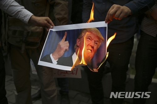【테헤란=AP/뉴시스】9일(현지시간) 이란 수도 테헤란에서 시위대가 도널드 트럼프 미국 행정부의 이란 핵협정 탈퇴에 항의하며 트럼프의 사진을 태우고 있다. (출처: 뉴시스) 2018.5.10.