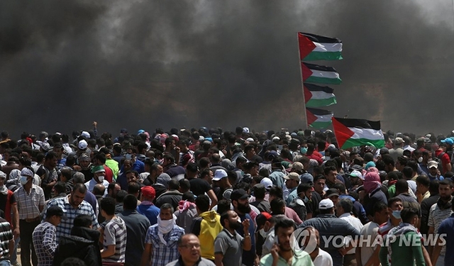 14일 가자지구 남부의 이스라엘과의 접경에서 미 대사관의 예루살렘 이전에 항의하는 시위대 쪽으로 최루가스와 타이어를 태운 연기가 몰려오는 모습. (출처: 연합뉴스)