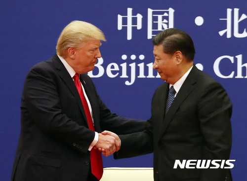 도널드 트럼프 미국 대통령과 시진핑 중국 국가주석이 작년 11월 베이징 인민대회당에서 미중 기업들 간의 협약식에 참석해 악수하고 있다. (출처: 뉴시스)