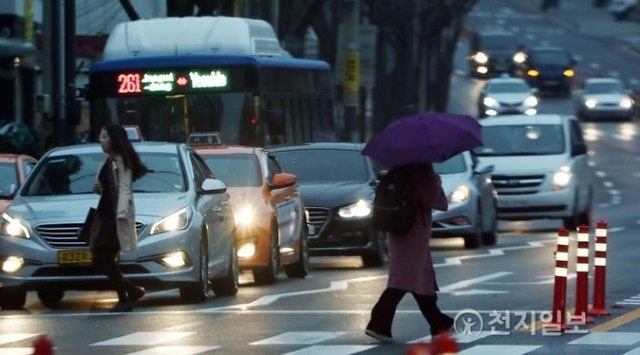 [천지일보=박완희 기자] 비가 내리고 안개 낀 날씨를 보인 19일 오전 서울 마포구 공덕오거리 인근에서 출근길 시민이 우산을 쓴 채 길을 건너고 있다. ⓒ천지일보(뉴스천지) 2018.3.19