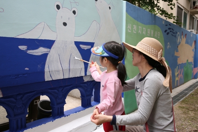 24일 공원에 놀러온 어린이가 엄마와 함께 벽화 그리기에 동참 하고 있다. (제공: 구리지부)ⓒ천지일보(뉴스천지) 2018.5.25