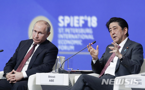 러시아를 방문한 아베 신조(安倍晉三) 일본 총리(오른쪽)가 25일 상트페테르부르크에서 열린 국제경제 포럼에서 블라디미르 푸틴 대통령과 이냐기를 나누고 있다. (출처: 뉴시스)