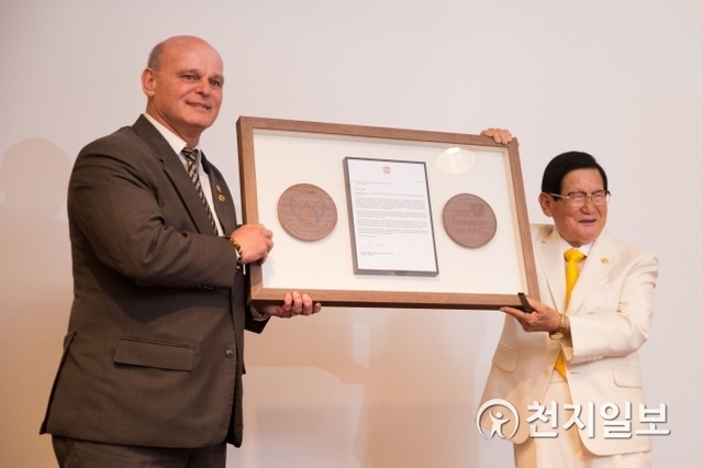 Dr. Manfred F. Welker, a member of Frankfurt City Council, delivering a letter of support for the peaceful unification of the Korean Peninsula to HWPL Chairman Man Hee Lee at the peace forum in Frankfurt, Germany on 12 May 2018.