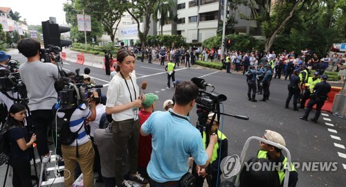 (싱가포르=연합뉴스) 북미정상회담을 이틀 앞둔 10일 오후 싱가포르 세인트 리지스 호텔에서 취재진과 시민들이 김정은 위원장을 기다리고 있다.