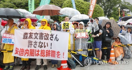 (도쿄 교도=연합뉴스) 10일 일본 시민들이 일본 국회의사당 앞에서 집회를 열고 아베 신조(安倍晋三) 일본 정권의 퇴진을 촉구하고 있다. 장맛비가 내리는 가운데 열린 이 날 집회에는 주최측 추산 2만7천명의 시민들이 참가했다. 2018.6.10