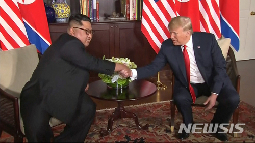 12일 오전 김정은 북한 국무위원장과 도널드 트럼프 미국 대통령이 싱가포르 센토사섬 카펠라 호텔에 마련된 회담장에서 악수를 나누고 있다. (출처: 뉴시스)