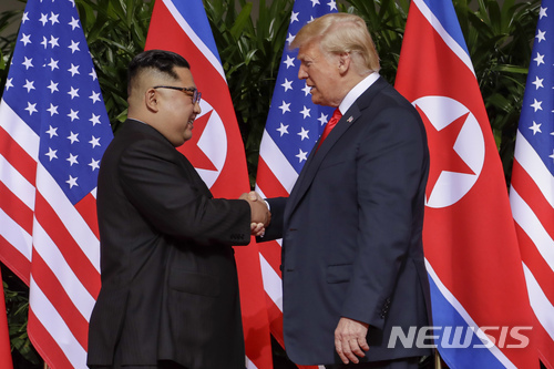 【싱가포르=AP/뉴시스】 김정은 북한 국무위원장과 도널드 트럼프 미국대통령이 12일 싱가포르 카펠라 호텔에서 처음 만나 악수하고 있다.