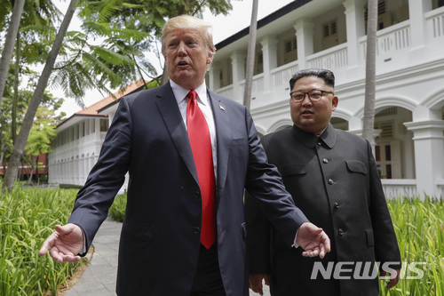 【싱가포르=AP/뉴시스】김정은 북한 국무위원장(오른쪽)과 도널드 트럼프 미 대통령이 12일 싱가포르 센토사섬에 있는 카펠라 호텔에서 오찬을 마친 뒤 산책하던 중 기자들과 이야기하기 위해 걸음을 멈추고 있다.