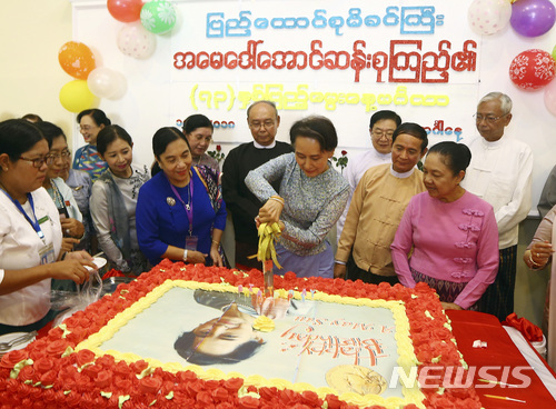 【네피도(미얀마)=AP/뉴시스】미얀마 최고 지도자 아웅산 수지 여사(가운데)가 자신의 73번째 생일은 맞은 19일 수도 네피도에서 집권 민주주의민족동맹(NLD) 관계자들의 축하를 받으며 생일 케이크를 자르고 있다.