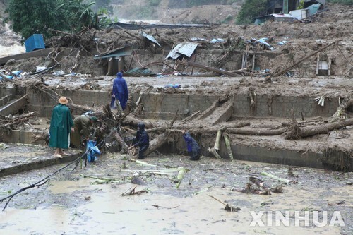 24일 베트남 북부 라이쩌우 성에서 발생한 홍수와 산사태로 5명이 사망하고 12명이 실종된 가운데 구조대원들이 잔해를 치우고 있다. (출처: 뉴시스)