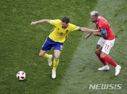 2018년 상트 페테르부르크 경기장에서 열린 2018년 월드컵 스위스와 스웨덴의 16강전에서 스웨덴의 마커스 버그(왼쪽)가 스위스의 발론 베라미와 공을 다투고 있다. (출처: 뉴시스)